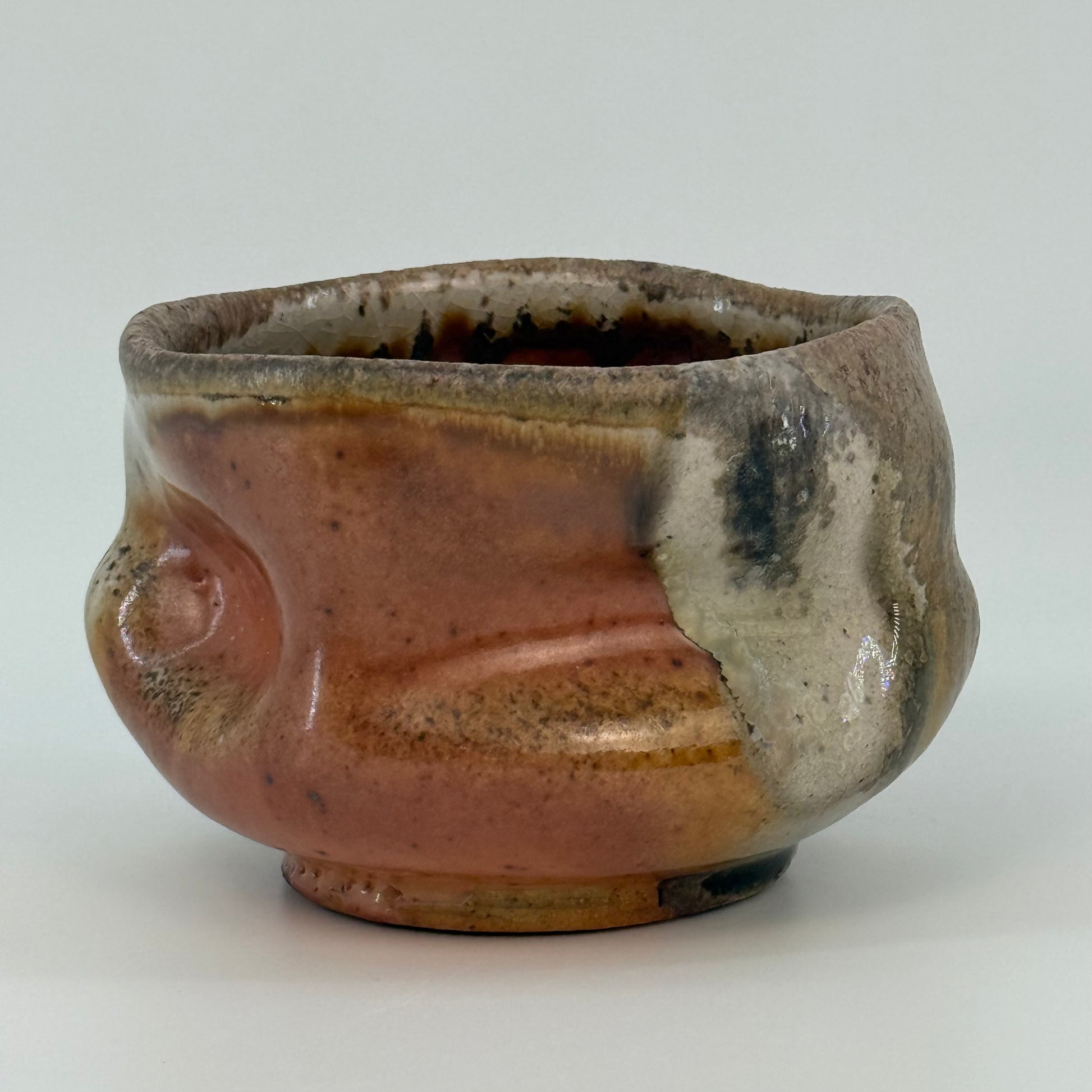 Ceramic bowl with brown and beige glaze on a white background