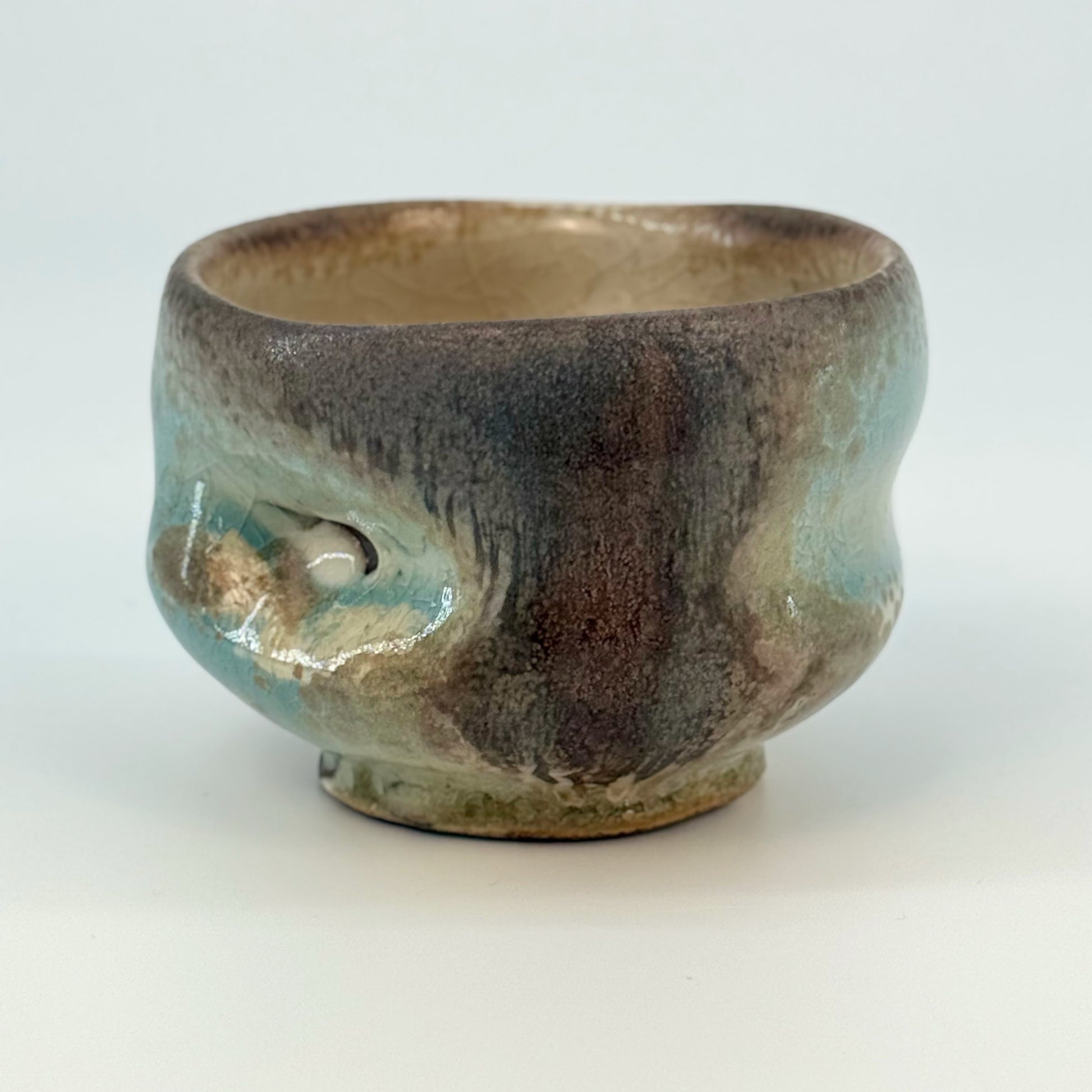 Ceramic cup with gray and blue glaze on a white background