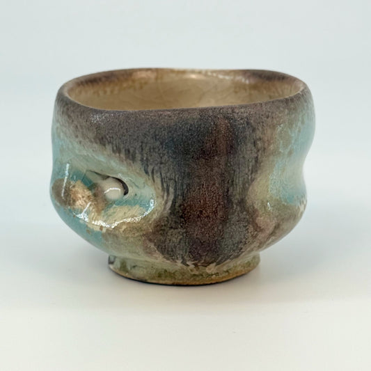 Ceramic cup with gray and blue glaze on a white background